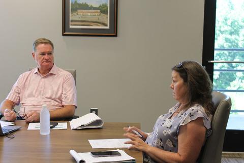Pilot Michelle Curcio (right) talks to the Airport Commission on Tuesday as County CFO Tim Sims listens.