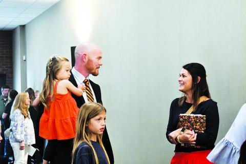 Adam Bagwell holds his daughter Emi while chatting with Clarkesville  Elementary Assistant Principal Kellie Cash. JULIANNE AKERS/Staff