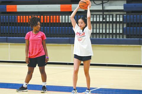 Camper Harmony Warren looks on as former Lady Raider Jazky Bantaum demonstrates an overhead pass. LANG STOREY/Staff
