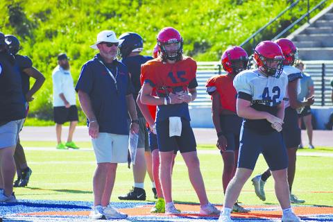Coach Benji Harrison and quarterback DJ Pass look on as the second team lines up during padded camp. LANG STOREY/Staff