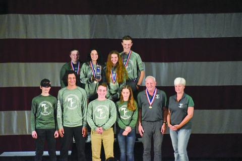 Tallulah Falls’ national championship rifle team included (front row, from left) Zeek Pruitt, Marc Crotta, Ethan Simmons, Kylee Loudermilk, coach Tim Stamey and assistant coach Kerry Stamey. Back row are (from left) Leah Rogers, Brianna Walter, Chloe Erwin and Joseph McGahee. Right photo shows the trophy the Indians brought home. TALLULAH FALLS SCHOOL/Submitted 