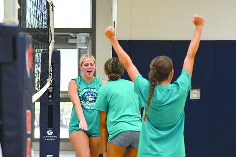 Ava Saxon (right) and McKenzie King hype up their teammate after Kinslee Hicks (far left) won a point during one of  Habersham Central’s summer camps. LANG STOREY/Staff 