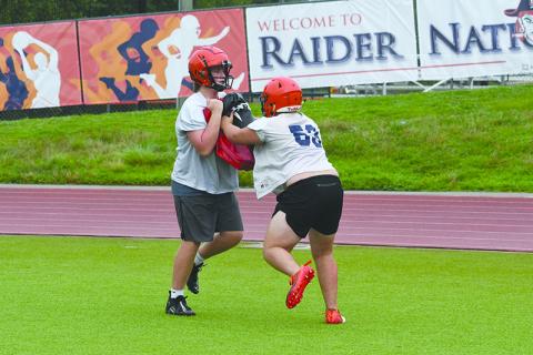 Landon Holbrook holds the bag while Dawson Barnett blocks at practice Thursday morning. LANG STOREY/Staff