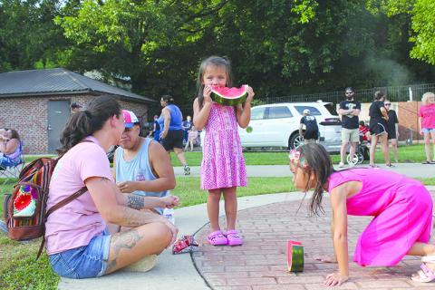 Samantha and Sergio Andres watch their kids Linda and Kylah devour watermelon at Baldwin’s Pit Nic Saturday. BRIAN WELLMEIER/Special
