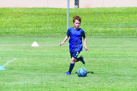 Finley Franklin pushes the ball upfield during a scrimmage game at Raider Soccer camp.
