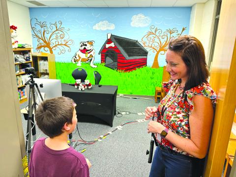 Ollie Osborne talks with media specialist Annabelle Wiley about Level Grove Elementary’s Bulldog Broadcast, which is run by fifth graders with staff supervision, at the school’s open house Wednesday. MATTHEW OSBORNE/Staff 