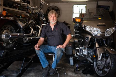 Kenneth Pardue sits beside motorcycles in his shop, Rooster’s Cycles. ZACH TAYLOR/Staff