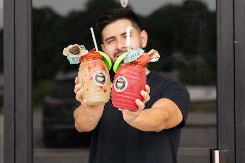 Luis Covarrubias holds at Raspas El Tigre a watermelon agua fresca and cucumber-lime agua fresca topped with ice cream and candy. ZACH TAYLOR/Staff