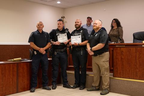 Chief Jones and Assistant Chief Ferguson stand with Corporal John Groves and Corporal Daniel Spivey after the two were honored with Lifesaving Awards at Monday night’s city council meeting. ZACH TAYLOR/Staff