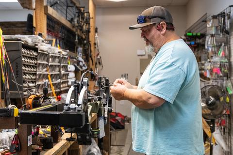 Greg Hope tunes a new bow in a bow press for a customer during a workday on Wednesday. Hope is one of two brothers who manage the archery, gun and shooting range business in Demorest. ZACH TAYLOR/Staff 