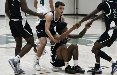 Neyo Bain is helped to his feet by teammates after missing a buzzer beater at the end of the 1st half Saturday. LANG STOREY/Staff
