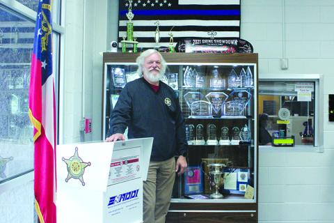 Sheriff Joey Terrell stands in front of the trophies detailing the police department’s accolades. HANNAH CAUDELL/Staff