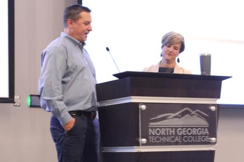 From left, Ty Akins and Alicia Vaughn talk economic development at the State of the County address on Tuesday. HANNAH CAUDELL/Staff