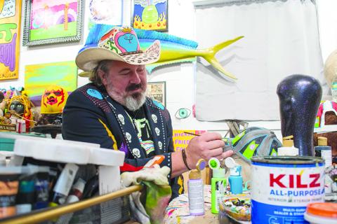Chris Allison paints a hat at his art studio in Mt. Airy. JULIANNE AKERS/Staff