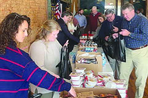 Members of the Habersham Kiwanis Club help pack bags of food for kids in the community. SUBMITTED