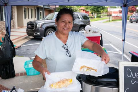 The City of Cornelia hosted many events for Hispanic and Latin culture over the past few years that helped it earn one of three 2025 Visionary City Awards by the Georgian Municipal Association in the small city category. Pictured here, Orlanda Marroquin holds an elote and a fresh taco at a festival in downtown Cornelia in July and runs a small business selling Hispanic foods and treats. ZACH TAYLOR/Staff 