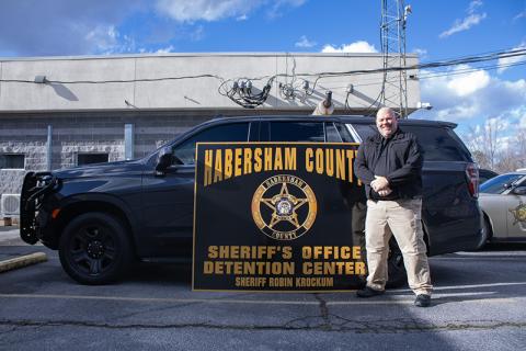 Robin Krockum is the new sheriff in town as of Jan. 1, 2025. Krockum stands before a police vehicle with the new sheriff office sign, his name emblazoned at the bottom. HANNAH CAUDELL/Staff