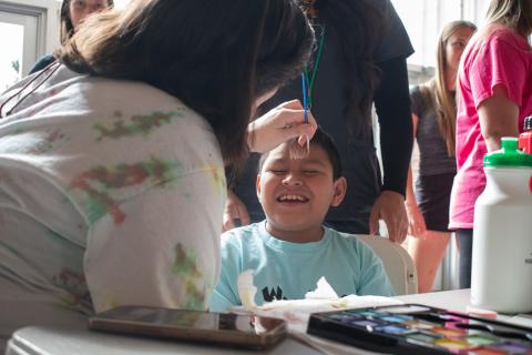 Mateo Mateo-Diego gets into the Lion Pride spirit while a volunteer paints his face to resemble the cat’s signature mane. HANNAH CAUDELL/Staff