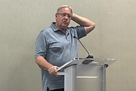 Dale Green stands at the podium to speak before the board on Thursday night to express his early concerns about the school system’s impending budget decision. HANNAH CAUDELL/Staff