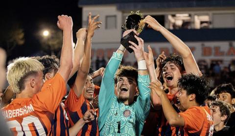 Surrounded by teammates, HCHS keeper Everett Rudeseal hoists the region trophy after the Raiders clinched another championship Thursday night. HABERSHAM SOCCER