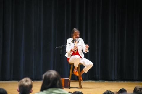 Carmen Agra Deedy sits on the stage of the Habersham Central Performing Arts Center, miming as she tells the story of Juan Bobo, a Spanish wise-fool’s tale that has the students in the audience spellbound. HANNAH CAUDELL/Staff