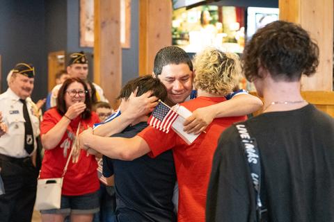 CWO-3 Jose Saravia hugs his sons, Eli Saravia, Christian Saravia and Gabe Lorenzo after surprising them at Bigg Daddy’s in Cornelia after being deployed for more than seven months. ZACH TAYLOR/Staff