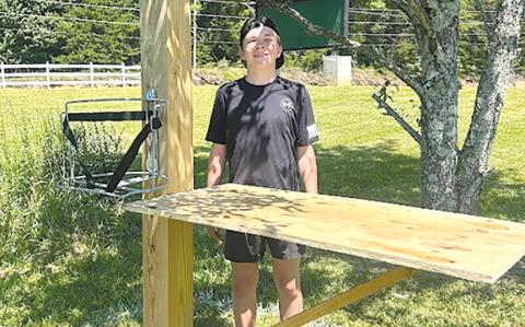 Thatcher Tatum shows one of the water stands he led a team of Scouts and leaders to build last summer at Tallulah Falls School. SUBMITTED