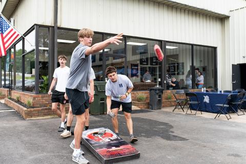 Habersham Central basketball stars and All-Regions pick Judge and Paris Wilbanks play cornhole at Crown Athletics’ grand opening ceremony on Saturday. ZACH TAYLOR/Staff