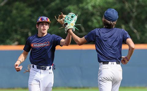 Habersham Central High School’s Tanner Yarbrough and Asa Popham tap gloves during the orange and blue series on Thursday, June 19 at Raider Park. The orange team won both games. (Landen Todd/Staff)