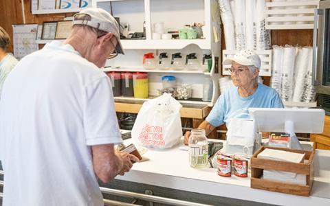 Gertrude Williams (right) rings up a customer at lunchtime at Stew N Que on Thursday. (Zach Taylor/Staff)
