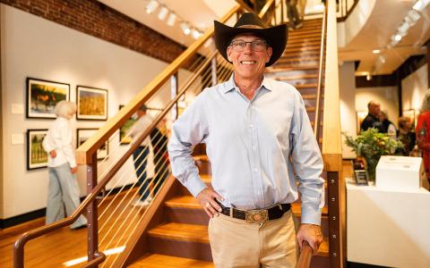 Photographer and filmmaker Rhett Turner poses for a photo on the staircase of the Mason-Scharfenstein Museum of Art, where his exhibit is currently on display. (Zach Taylor/Staff)