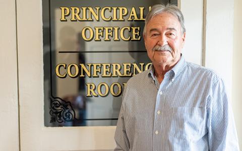 Mayor Ray McAllister stands in front of the principal’s office door of the old schoolhouse, now his office and town hall. (Zach Taylor/Staff)