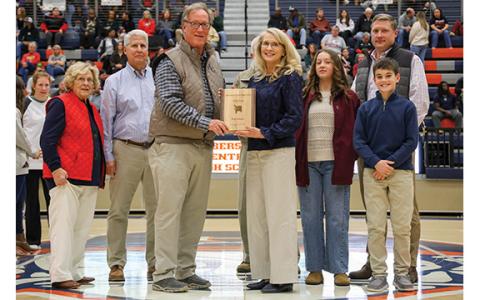 Left to right: Mother, Margaret Tench, husband, Stan Gunter, HCHS Athletic Director Geep Cunningham, Rita Tench Gunter, dad, Charles Tench (hidden), granddaughter Cayden, son Chase and grandson Westin pose during the basketball hall of fame ceremony at the Raider Gymnasium on Friday, Dec. 19. (Landen Todd/Staff)