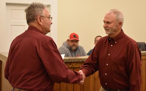 Newest Mt. Airy councilman Sam Wilbanks (right) shakes hands with Mayor Ray McAllister after he is sworn in on Monday night. (Hannah Caudell/Staff)