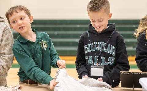 TFS Fourth graders Taylor Peckham and Decklan Densmore work to tie blankets for the animal shelter. (Zach Taylor/Staff)