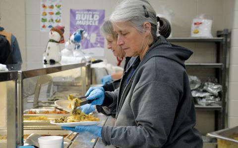 Food Factory’s Lisa Short scoops food on a plate for a lineman Wednesday night. (Samantha Sinclair/Staff)