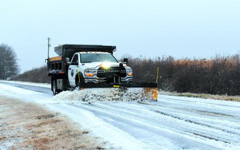 A Baldwin Public Works truck scrapes slush off Airport Road Sunday afternoon. (Samantha Sinclair/Staff)