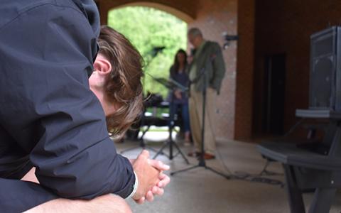 A young man prays at Demorest Springs Park during last year's Day of Prayer event. (Photo/Samantha Sinclair)