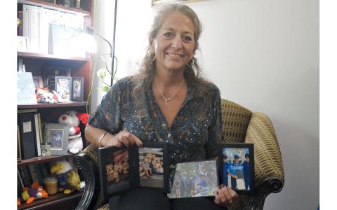Dr. Fran Chastain shows some of her favorite photos of her 13 children and nine grandchildren in her office at North Georgia Technical College. She has 13 children, 11 of which were adopted. (Samantha Sinclair/Staff)