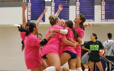 The Lady Raiders jump and hug in celebration during the All-American Volleyball Camp at the Raider Gymnasium on Monday, July 27.  (Landen Todd/Staff)