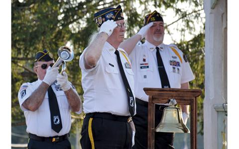 As Ken Franklin plays Taps, Dr. Ed Hendricks and Dana McCloud salute. (Samantha Sinclair/Staff)