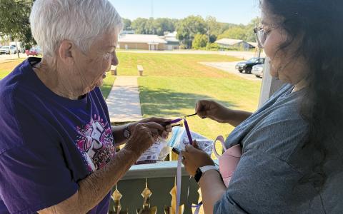 Myloe Moore and Tania Morales light a candle for domestic violence victims during Circle of Hope’s fifth annual Hope Walk held last week. (Submitted)