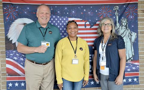Poll workers Scott Brown, Laqueda Scott and Stephanie Martin show off the ‘I voted’ stickers available for voters at the selfie station set up at the elections office. (Samantha Sinclair/Staff)