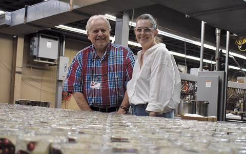 Rush Mauney poses with his daughter, Jessamine Cantey, as candles come down the production line at GlobalTech last year. (Samantha Sinclair/Staff)