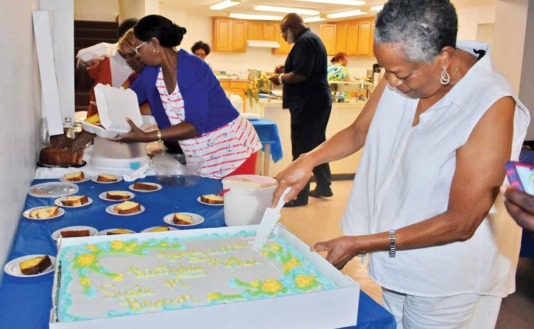 Gwen Brown, daughter of Susie Brown, cuts the cake at Susie Brown’s 100th birthday party earlier this month at a Clarkesville church. (Photo/CHAMIAN CRUZ)