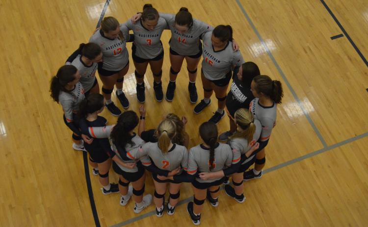 The HCHS Volleyball team huddles during a timeout Thursday.