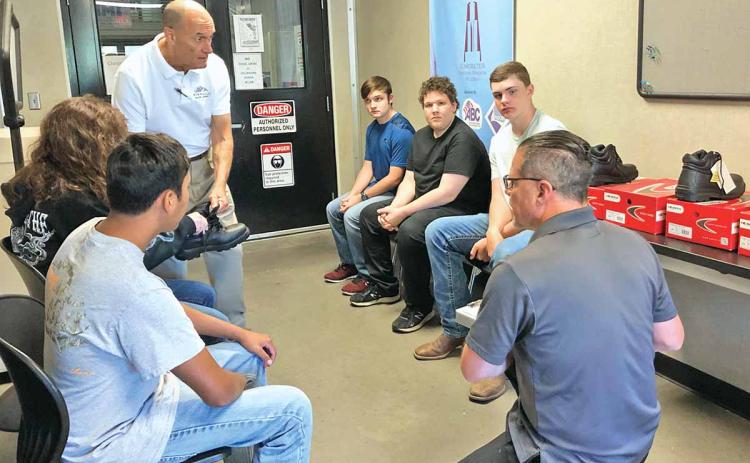 Habersham Central High School students in the dual-degree welding program at North Georgia Technical College were fitted Thursday morning for their safety boots. Students shown sitting in a circle, left to right, are 10th-grader Gabe Blackburn, 12th-grader Katie McCoy, 11th-grader Joshua Brock, 11th-grader Adrian Frankum and 10th-grader Drew Maneg. (Photo/CHAMIAN CRUZ)