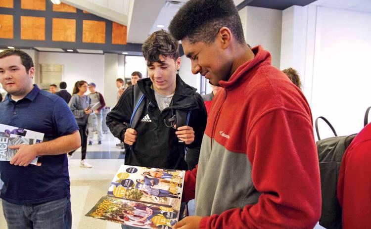 Habersham Central High School (HCHS) seniors Brett Browner, right, and Jose Bravo, center, check out a brochure from Georgia Southern University at the annual College PROBE Fair. About 50 colleges and universities visited HCHS Thursday to connect with students about post-secondary education opportunities. (Photo/ERIC PEREIRA)