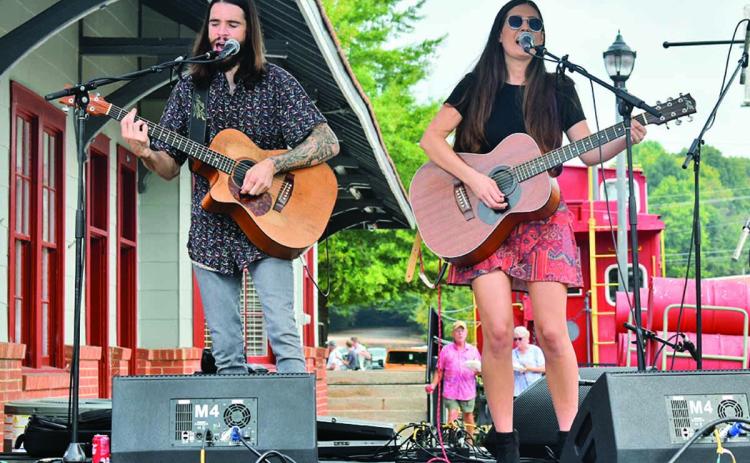 “Leaving Lennox,” comprised of Mick Hambly and Lauren Val, perform on stage in downtown Cornelia singing a song to the hundreds of attendees of the Big Red Apple Festival Saturday, Sept. 28. They sang a mix of covers and original songs. (Photo/CHAMIAN CRUZ)