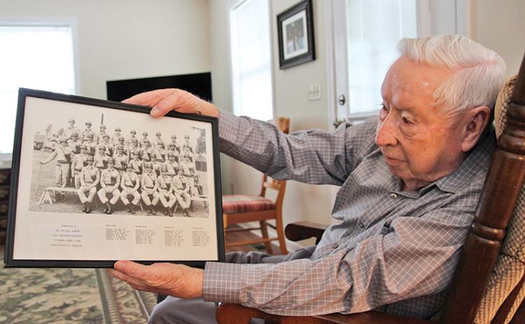 Donald Tench shows a photo from his Army days. Tench, 90, served 38 years in the Army and reserves. He continues to participate in military funerals which he has done for over 60 years.